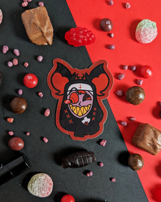 A sticker of Alastor from Hazbin Hotel dressed as a nun against red and black background with red, black, and brown candies.
